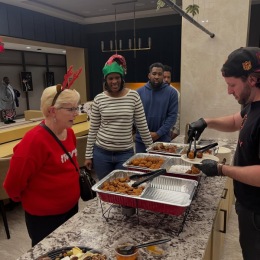 people waiting in line to be served food