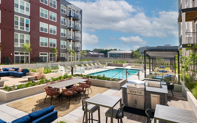 a courtyard with a pool, tables and chairs